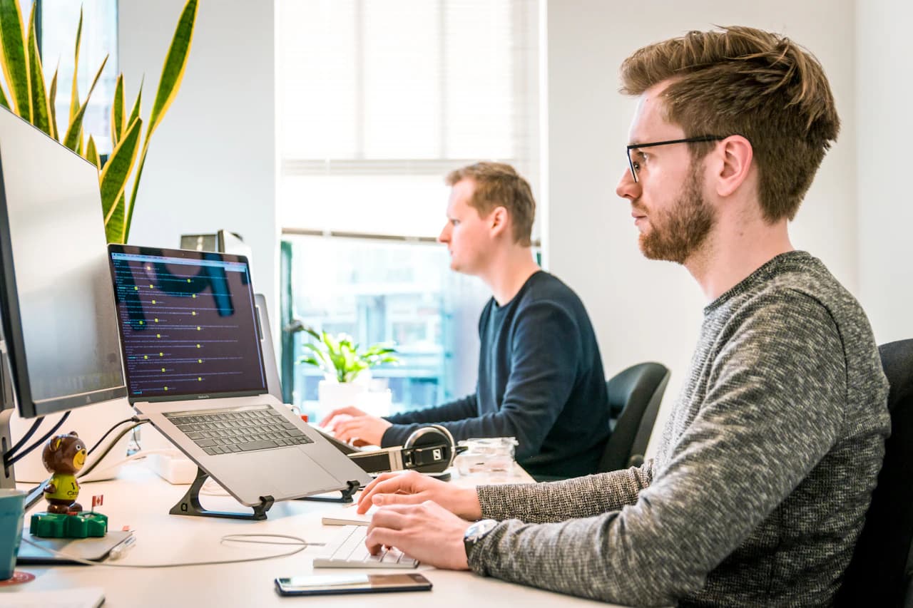 Business analyst and engineer reviewing AI-assisted workflow output on a desktop interface
