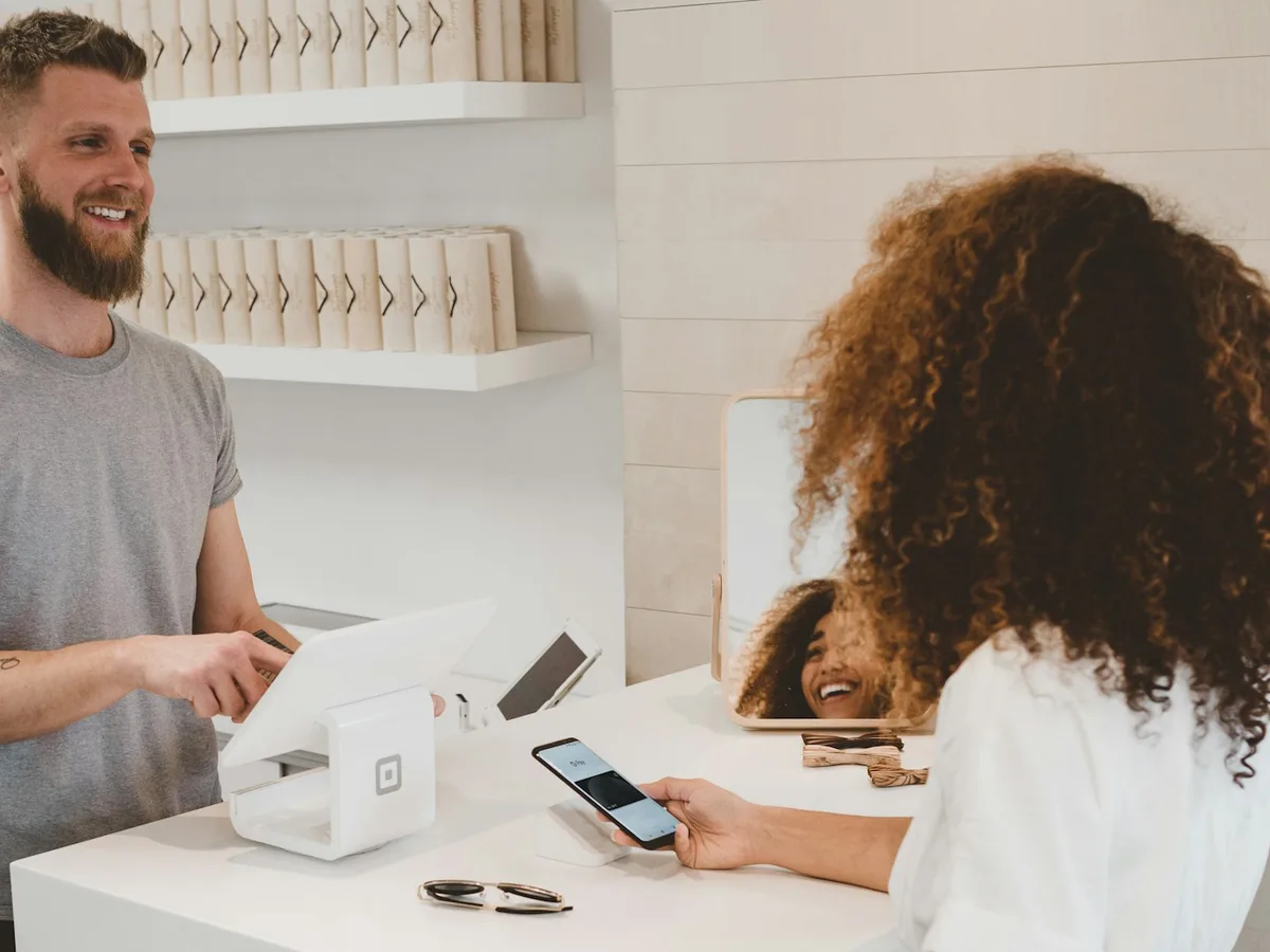 Store operator processing a customer transaction at a retail point-of-sale counter